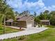 Aerial view features a long driveway, lawn, and detached garage with a screened in porch at 4044 Red Fox Ct, Wesley Chapel, FL 33543