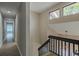 Hallway with hardwood floors leading to the main entryway, featuring natural lighting and white walls at 4044 Red Fox Ct, Wesley Chapel, FL 33543