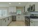 Bright kitchen features white cabinets, stainless steel appliances, and marble countertops at 4044 Red Fox Ct, Wesley Chapel, FL 33543