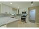 Modern kitchen boasts stainless appliances, white cabinets, marble counters and tiled backsplash at 4044 Red Fox Ct, Wesley Chapel, FL 33543