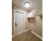 Laundry room with wood-look flooring, white cabinets and door at 4044 Red Fox Ct, Wesley Chapel, FL 33543