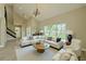Staged living room features large windows providing abundant natural light, and a modern light fixture at 4044 Red Fox Ct, Wesley Chapel, FL 33543