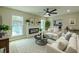 Staged living room features a modern fireplace, ceiling fan, and access to the kitchen at 4044 Red Fox Ct, Wesley Chapel, FL 33543