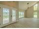 Bright living room with vaulted ceilings, large windows, and decorative front door at 4044 Red Fox Ct, Wesley Chapel, FL 33543