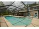 A screened-in pool featuring a tanning shelf and ample seating creates a perfect setting for relaxation and enjoyment at 4044 Red Fox Ct, Wesley Chapel, FL 33543