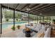 Serene screened-in pool area with a modern lounge, dining space, and lush landscaping at 4044 Red Fox Ct, Wesley Chapel, FL 33543