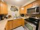 Well-equipped kitchen with stainless steel appliances and wood cabinets at 4214 Trucious Pl # 4212, New Port Richey, FL 34652