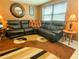 Inviting living room with a comfortable black leather sectional couch, and unique brown rug at 4214 Trucious Pl # 4212, New Port Richey, FL 34652