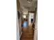 Hallway with gleaming hardwood floors and natural light entering rooms through open doorways and windows at 4304 Harbor House Dr, Tampa, FL 33615