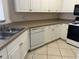Kitchen featuring white cabinets, tile backsplash, and stainless steel sink at 4305 Bayside Village Dr # 301, Tampa, FL 33615