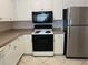 Kitchen featuring white cabinets, tile backsplash and stainless steel appliances at 4305 Bayside Village Dr # 301, Tampa, FL 33615