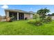 Lush backyard with green grass, a screened lanai, and a garden, offering a serene outdoor space at 5006 Jackel Chase Dr, Wimauma, FL 33598