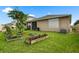 Well-maintained backyard with lush green grass, privacy fence, small garden plots, and view of the house at 5006 Jackel Chase Dr, Wimauma, FL 33598
