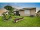 Well-maintained backyard with lush green grass, privacy fence, small garden plots, and view of the house at 5006 Jackel Chase Dr, Wimauma, FL 33598