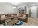 Living room featuring tile flooring, a large sofa, and a built-in bookshelf at 5006 Jackel Chase Dr, Wimauma, FL 33598