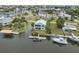 An aerial view of the home on the water, showing the back, dock, other neighborhood homes and water access at 5070 Cedarbrook Ln, Hernando Beach, FL 34607