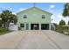 View of the two car garage, large driveway, door to the lower level and steps up to the main living area at 5070 Cedarbrook Ln, Hernando Beach, FL 34607