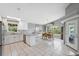 Open kitchen and dining area with white cabinets, granite countertops, and lots of natural light at 5070 Cedarbrook Ln, Hernando Beach, FL 34607
