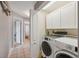 Convenient laundry room featuring white cabinets, washer, and dryer at 5070 Cedarbrook Ln, Hernando Beach, FL 34607