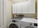 Functional laundry room featuring white cabinets, washer, and dryer at 5070 Cedarbrook Ln, Hernando Beach, FL 34607