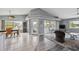 Living room and dining area with high ceilings, tile and wood look flooring, and access to the screened porch at 5070 Cedarbrook Ln, Hernando Beach, FL 34607