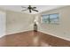 A bright bedroom with a ceiling fan, wood flooring, and a window with neighborhood views at 5078 Florentine Ct, Spring Hill, FL 34608