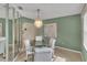 A dining area with a glass table, upholstered chairs, and a decorative chandelier, next to mirrored wall at 5078 Florentine Ct, Spring Hill, FL 34608