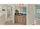 Hallway featuring a built-in bar area with wood cabinets and a view of the outdoor pool area at 5078 Florentine Ct, Spring Hill, FL 34608