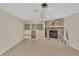 Bright living room featuring a stone fireplace, built-in shelving, and neutral tile flooring at 5078 Florentine Ct, Spring Hill, FL 34608
