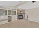 Open living room featuring tile floors, a stone fireplace, built-in shelving, and a ceiling fan at 5078 Florentine Ct, Spring Hill, FL 34608