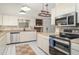 Bright kitchen features stainless steel appliances, granite countertops, and custom tile flooring at 5084 Barrington Cir # 3202, Sarasota, FL 34234