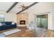 Cozy living room showcasing a stone fireplace, beamed ceilings, and sliding glass doors at 5084 Barrington Cir # 3202, Sarasota, FL 34234