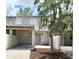 Charming townhouse featuring a covered parking area and a quaint front entrance with a tree in the landscaped yard at 5229 Tennis Court Circle, Tampa, FL 33617