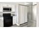 Galley kitchen showcasing stainless appliances, granite counters, and white cabinets at 5229 Tennis Court Circle, Tampa, FL 33617