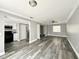 Open concept living room and kitchen with new gray flooring and modern appliances and closet storage at 5229 Tennis Court Circle, Tampa, FL 33617