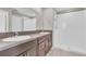 Elegant bathroom featuring double sinks with granite countertops and a modern walk-in shower at 5432 Rainwood Meadows Dr, Apollo Beach, FL 33572