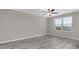 Bright bedroom features a ceiling fan, wood-look flooring, and a sunlit window at 5432 Rainwood Meadows Dr, Apollo Beach, FL 33572