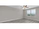 Bright bedroom features a ceiling fan, wood-look flooring, and a sunlit window at 5432 Rainwood Meadows Dr, Apollo Beach, FL 33572