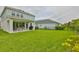 Expansive backyard featuring a covered patio, grill, and lush green lawn at 5511 Del Coronado Dr, Apollo Beach, FL 33572