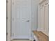 View of mudroom with white door, light wood bench with shoe storage, and coat hooks at 5511 Del Coronado Dr, Apollo Beach, FL 33572