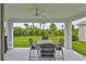 Covered patio features a ceiling fan and a tranquil view of the lush backyard landscaping at 5511 Del Coronado Dr, Apollo Beach, FL 33572
