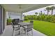 The covered patio features modern furniture and views of the manicured lawn at 5511 Del Coronado Dr, Apollo Beach, FL 33572