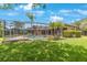 Landscaped backyard features a screened-in pool and patio, enhancing outdoor living and entertaining at 5519 Reflections Blvd, Lutz, FL 33558