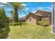 Lush backyard with privacy fence, tropical foliage, and a glimpse of the screened lanai at 5519 Reflections Blvd, Lutz, FL 33558