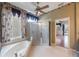 Lovely bathroom with soaking tub, glass shower, decorative wallpaper, and hardwood floors at 5519 Reflections Blvd, Lutz, FL 33558