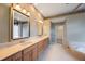 Primary bathroom with double vanity, large mirrors, garden tub, and walk in shower at 5519 Reflections Blvd, Lutz, FL 33558