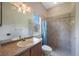 Bathroom featuring a single sink, window, and tile walk-in shower with blue shower curtain at 5519 Reflections Blvd, Lutz, FL 33558