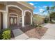 Inviting home entrance featuring double doors with glass panels, white columns, and well-maintained landscaping at 5519 Reflections Blvd, Lutz, FL 33558