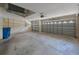Spacious two car garage with two garage doors, white walls, and blue trash cans at 5519 Reflections Blvd, Lutz, FL 33558