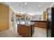 Open kitchen with a granite island, tile floors, and outdoor view at 5519 Reflections Blvd, Lutz, FL 33558